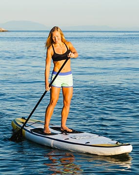 Woman standing and paddling on paddleboard